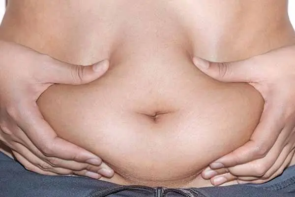 A woman is undergoing non-surgical belly fat removal.